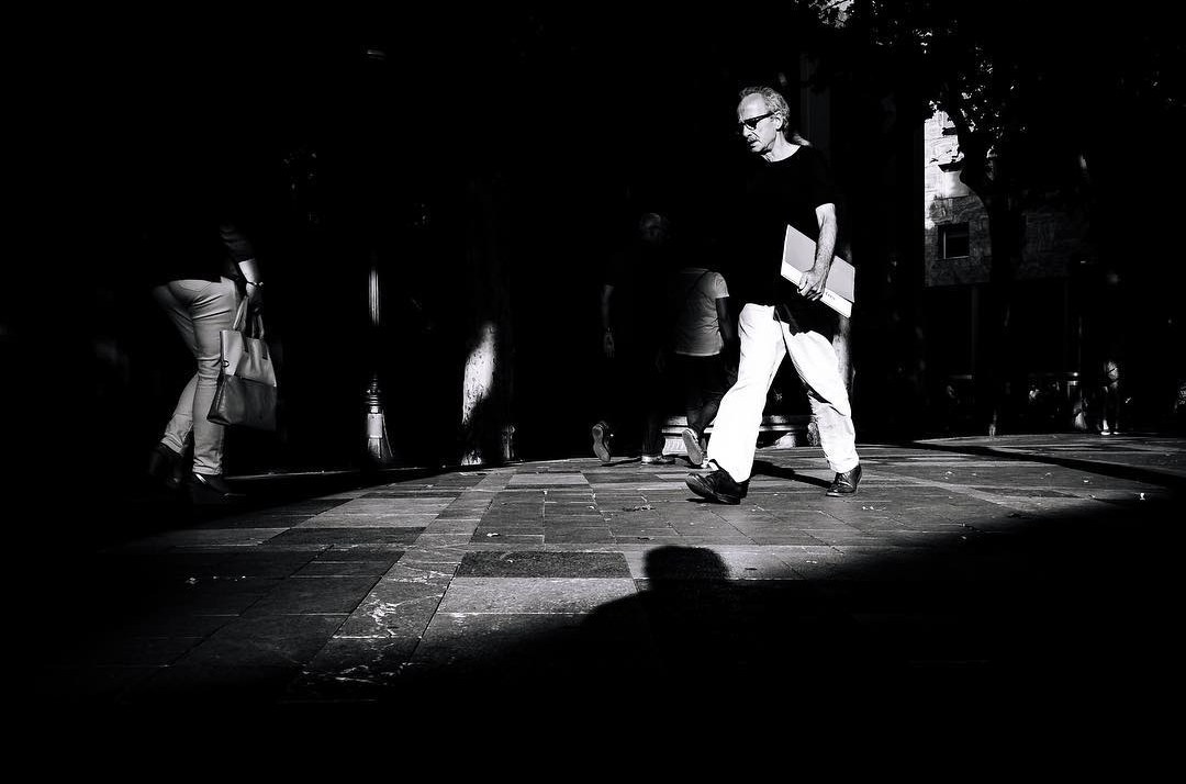 A person crossing a pool of light on a dark street